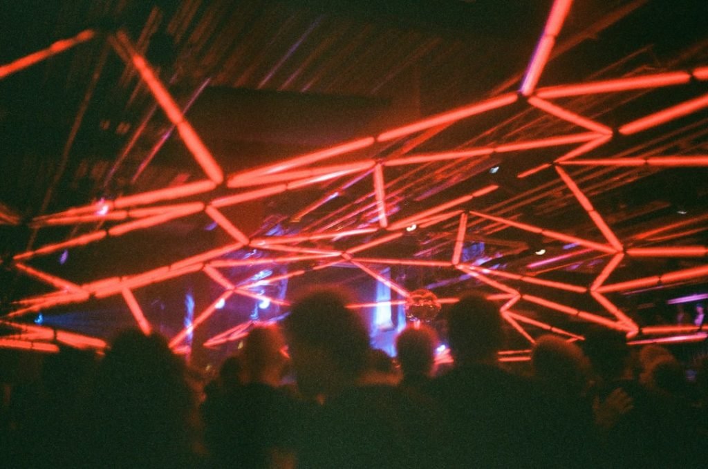 red-neon-lights-illuminate-a-crowded-room-bko7pbix6eo